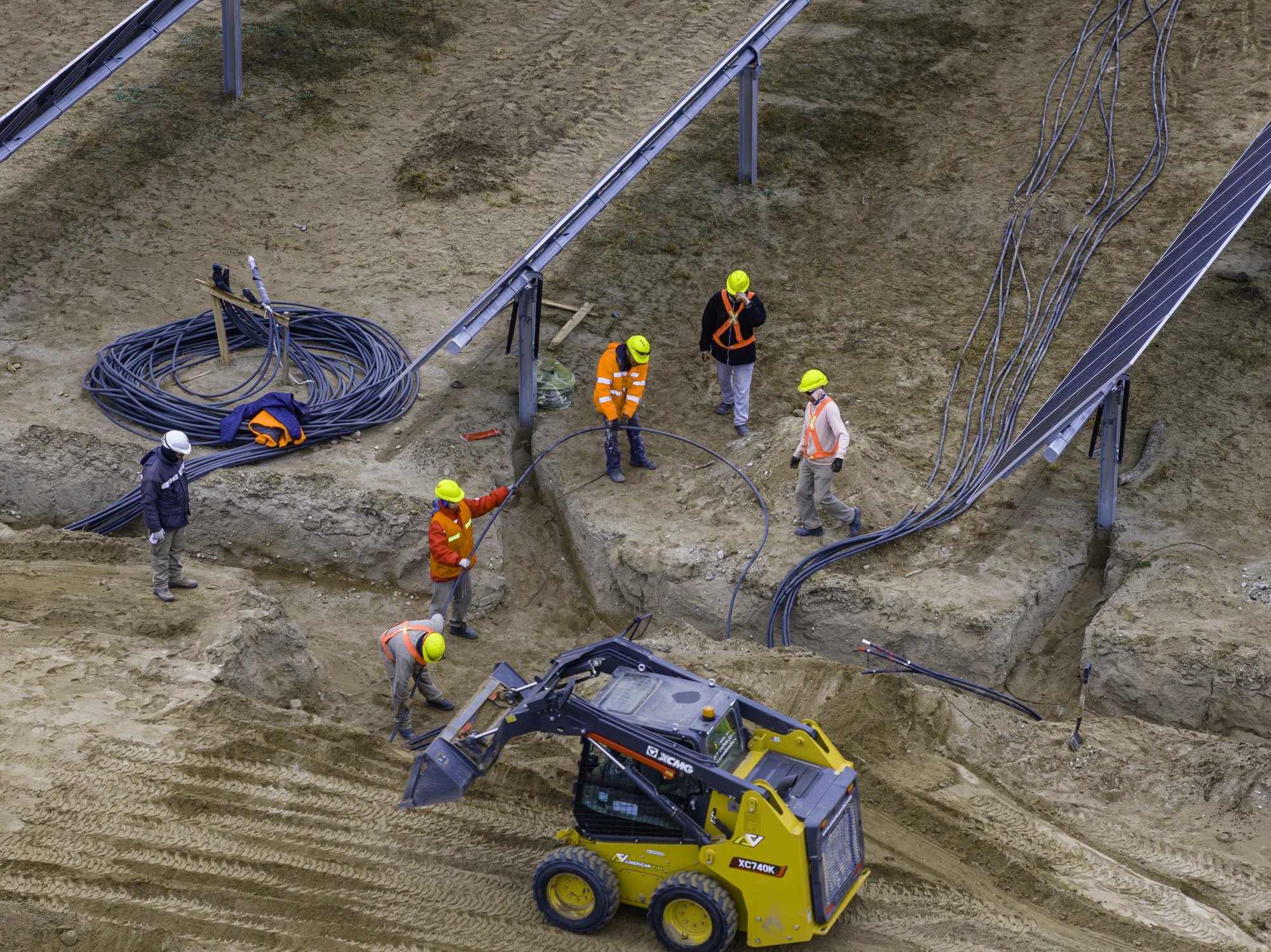 Operarios tendiendo cables en una zanja